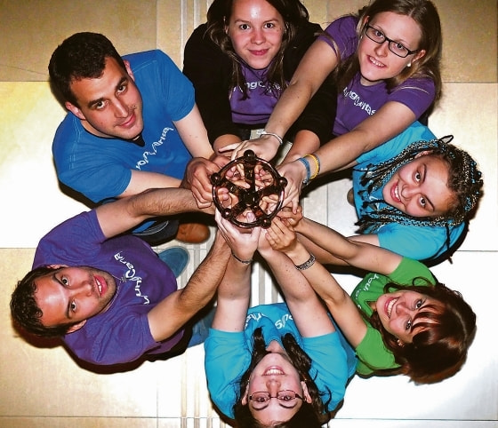 Solipreisträger/innen des actionPools der youngCaritas halten die Skulptur des Solidaritätspreises 2015 in die Höhe